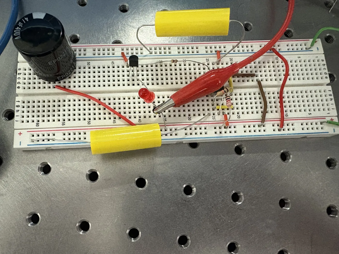 Breadboard receiver circuit with storage capacitor and LED on an optical bench plate